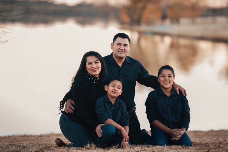 Photo of a multicultural family holding each other and smiling.