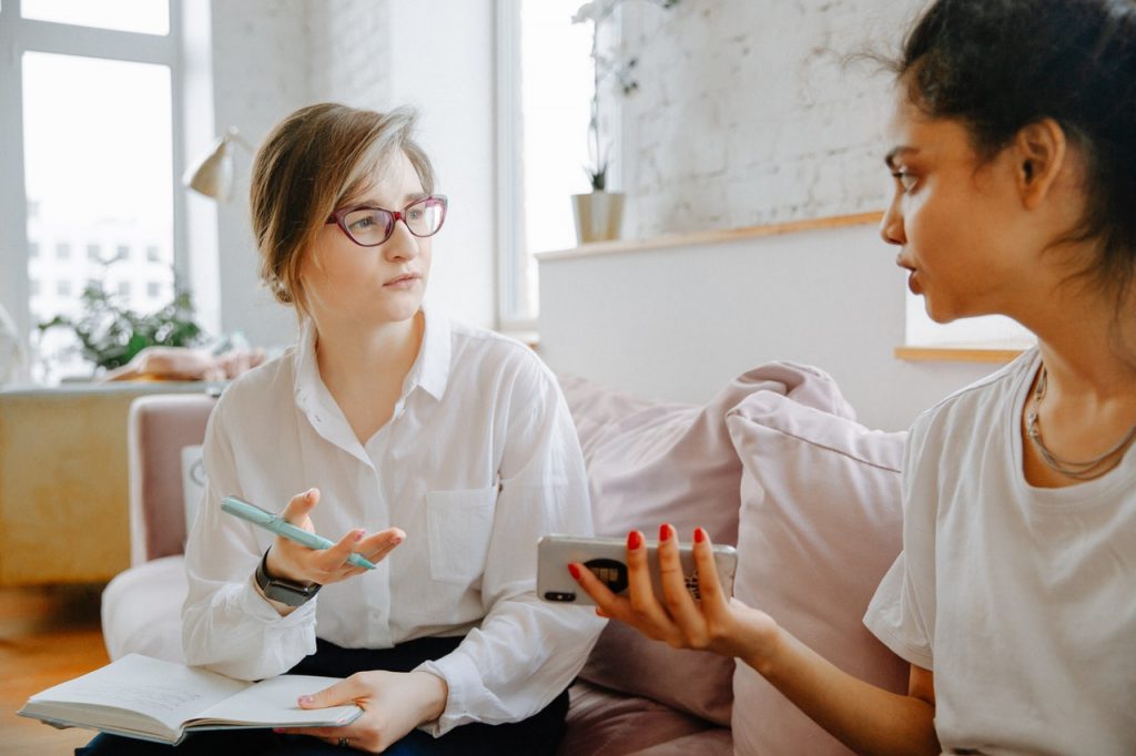 Photo of a young woman in a therapy session opening up about her relationship. This represents how the Gottman’s Four Horsemen theory can help you explore your communication style and how it impacts your relationship.