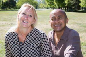 Photo of a multiracial couple smiling together. This represents how our therapists at Deep Connections Counseling can help you embrace your cultural differences and learn communication skills to decrease conflict and improve connections and intimacy with your partner.