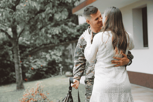 Photo of a military man returning home and holding his wife in a loving way. This represents how therapy sessions with our Deep Connections Counselors can help couples restore a sense of safety, intimacy, and friendship between partners.