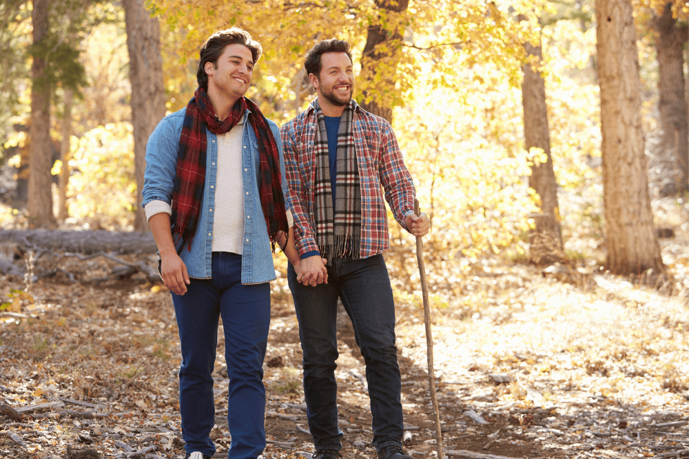 Photo of a LGBTQ+ couple walking together in nature. This represents how LGBTQ+ Couples Counseling in NC and VA can help you and your partner build a stronger, healthier, and closely connected bond.