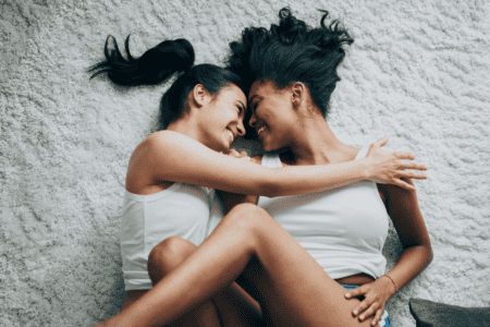 Photo of a LGBTQ+ couple holding each other and smiling. This represents how finding the right therapist in NC and VA can help you move forward and feel happy.
