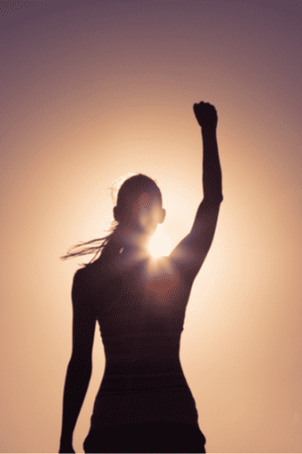 Photo of a woman feeling confident and celebrating with her arm up. This represents how multicultural counseling can help you gain life skills in the new environment when transitioning from another country.