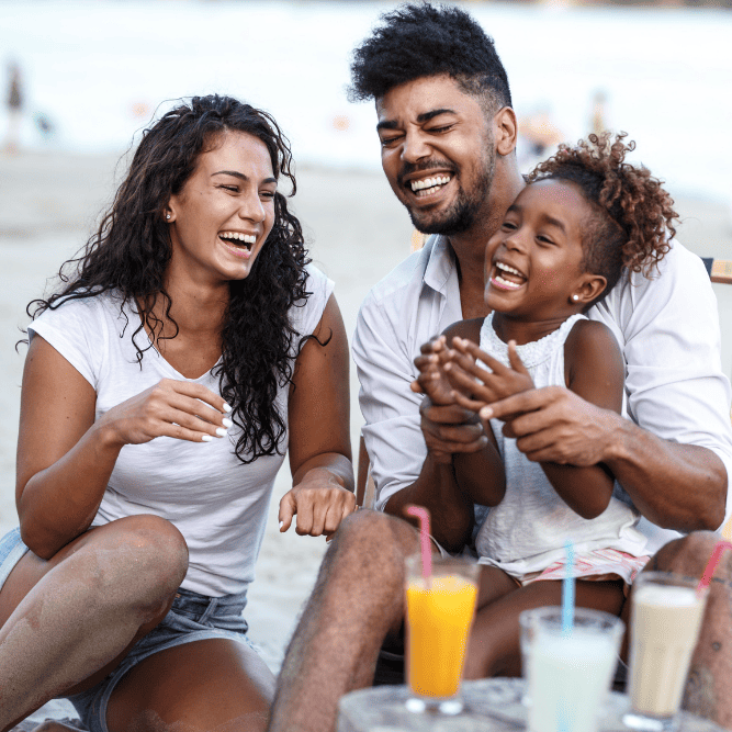 Photo of a multiracial family laughing together. This represents how a family and relationship therapist can help you reconnect with your loved ones and yourself.