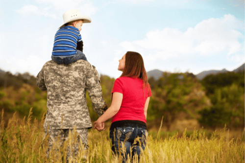 Photo of a military walking with his kid on his shoulders while holding hands with his wife. This represents how military counseling can help individuals, couples and families that are experiencing difficulties to get the help and support they need.