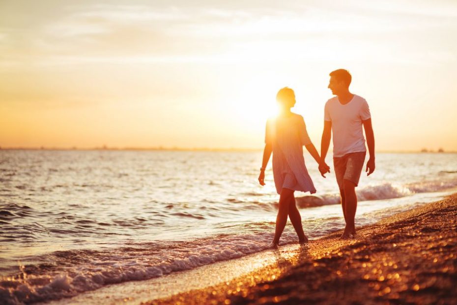 Photo of a couple walking in a beach and holding hands. Find the relationship therapist in NC and VA who works for you and achieve the connection and happiness you've been looking for.