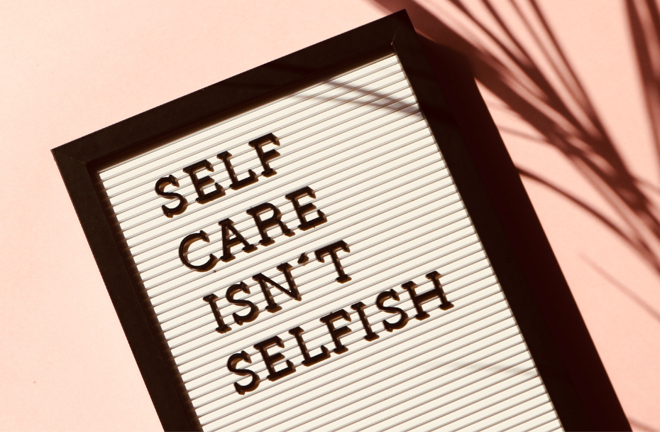 Photo of a screen with the words "Self care isn't selfish". This represents how focusing in your well-being and practicing self-care is a way to change your life by embracing your mental health.
