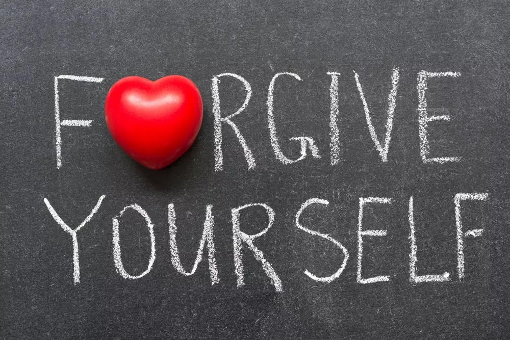 Photo of a blackboard with the phrase "Forgive Yourself" and a heart. The path to a better relationship is self-forgiveness. Learn how a closest relationship with yourself can empower you to become a better partner.