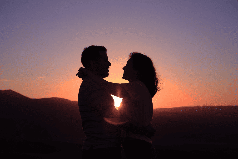 Photo of a couple holding each other at dawn. This represents how emotionally focused therapy techniques help couples connect.