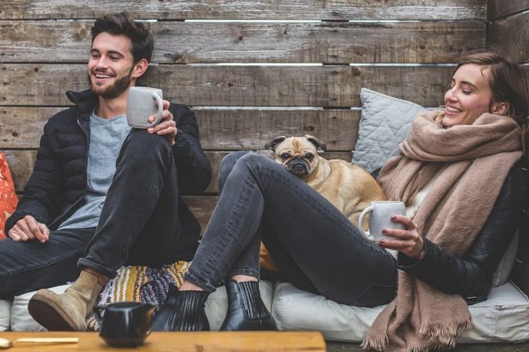 Photo of a young couple and their dog in a vacation cabin having fun. This represents how you and your partner can discover common ground and improve your relationship.