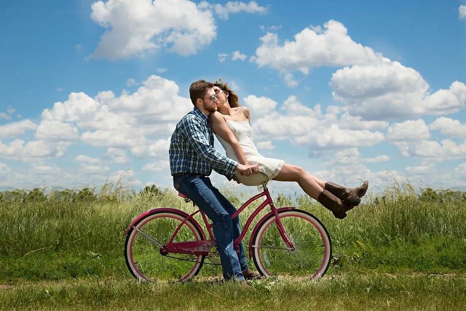 Photo of a couple riding a bike together. This represents how therapy can help strengthen your relationship.