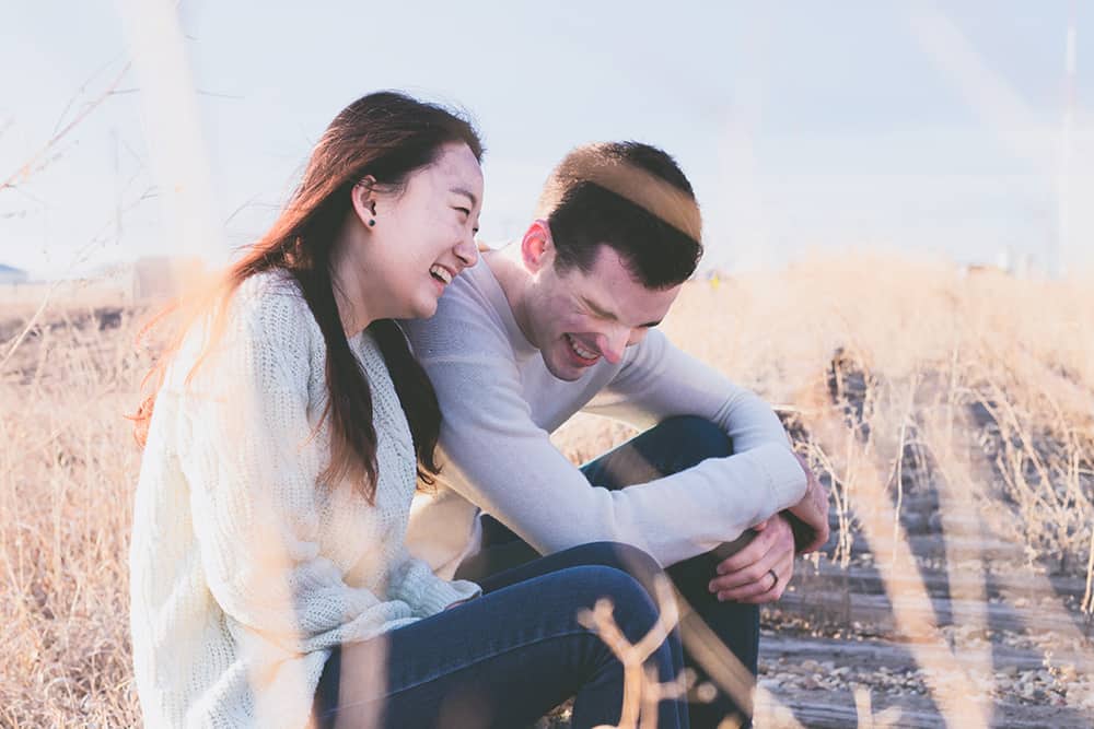 Photo of a couple laughing together. Fights with your partner can be a source of stress and impact your academic performance. College student relationship counseling can help you and your partner find happiness and connection in your relationship.