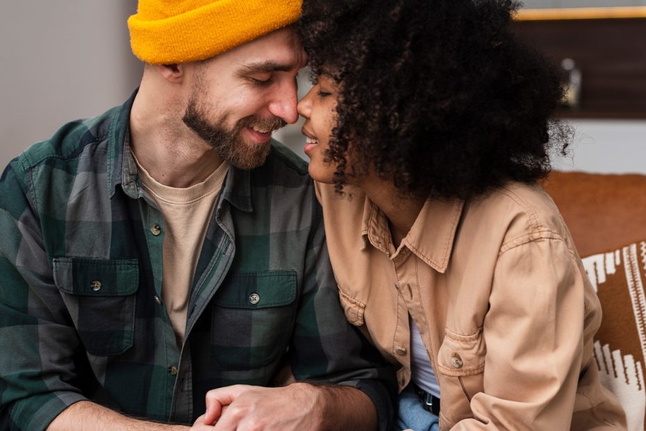 Photo of a couple holding hands and touching heads in a moment of open communication and connection. This represents how couples counseling can help with disagreements on having children.