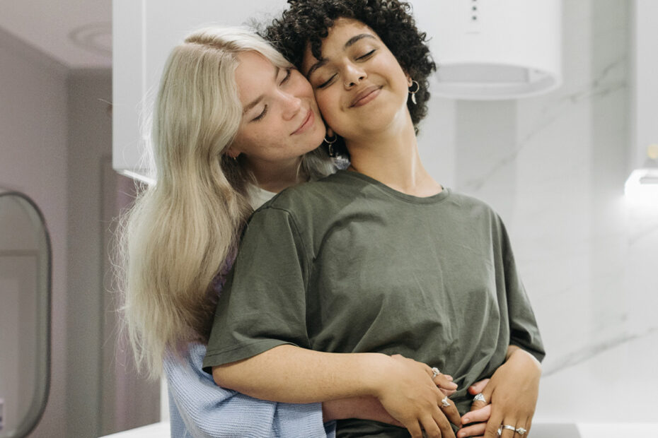 Photo of an LGBTQ+ couple hugging each other with a loving and calm expression. This represents how couples therapy can help rebuild trust in a relationship after a betrayal or infidelity.